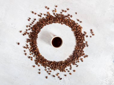 Kahve çekirdekleri çemberinin ortasında bir fincan espresso. Düz yerde, üst tarafta. Hafif arkaplan. Kahve için aşk.
