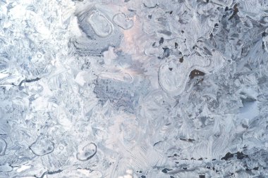 Camın üzerindeki buz deseni. Mavi-pembe arka plan. Kış soğuğu.