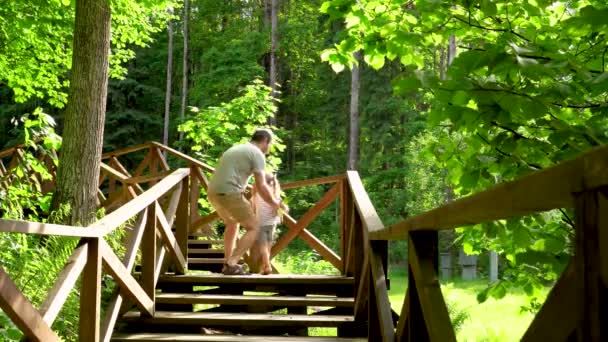 Familj semester i skogen. barnresa.stig med trädäck i skog — Stockvideo