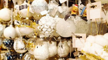 Cam Noel topları ve dekorasyonlar. Gümüş kozalaklı Noel ağacı süslemeli beyaz. Noel ağacı süslemeleri Noel pazarında satılıyor..