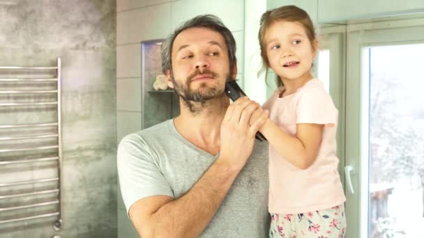 Putri dan ayah di kamar mandi sedang memotong rambut ayah melihat di cermin — Stok Video