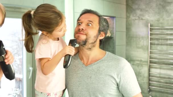 Dcera a táta v koupelně stříhají tatínky vlasy, dívají se do zrcadla — Stock video