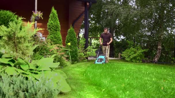 Opieka nad trawnikiem. Koszenie trawy z elektryczną kosiarką. zbieracz trawy — Wideo stockowe
