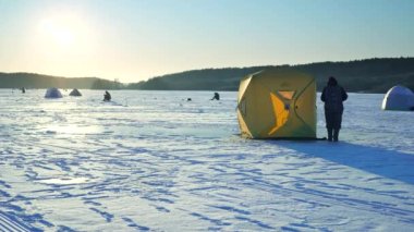 The fisherman sets up a tent on the ice for the convenience on the lake.