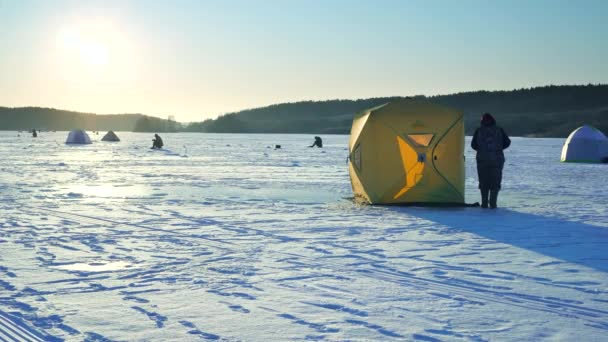 The fisherman sets up a tent on the ice for the convenience on the lake. — 비디오