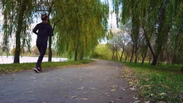 Mulher Correndo no Parque da Cidade Exercício ao ar livre. Esportista Ouvindo Música — Vídeo de Stock