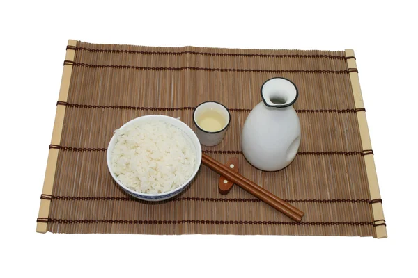 Sake and rice on a bamboo mat — Stock Photo, Image