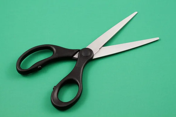 Nůžky na zeleném pozadí — Stock fotografie