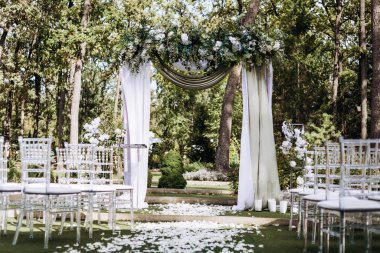 Açık havada kumaş ve çiçekli zarif düğün kemeri.