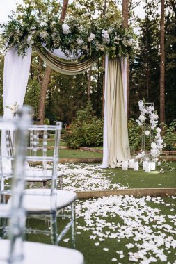 Açık havada kumaş ve çiçekli zarif düğün kemeri.