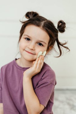 Yüz bakımı ve masaj için kuvars gua tutan çocuk.