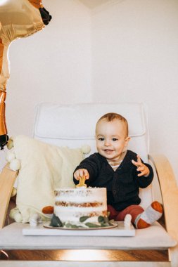 Elinde bir kaşık ve bir fincan çayla küçük sevimli bir oğlan.