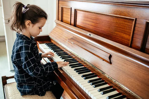 Küçük kız piyano çalıyor, çocuk müzik aleti çalmayı öğreniyor.