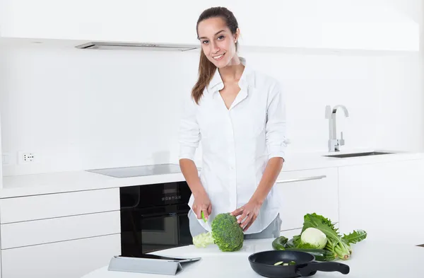 Jeune femme préparant la nourriture dans la cuisine — Photo