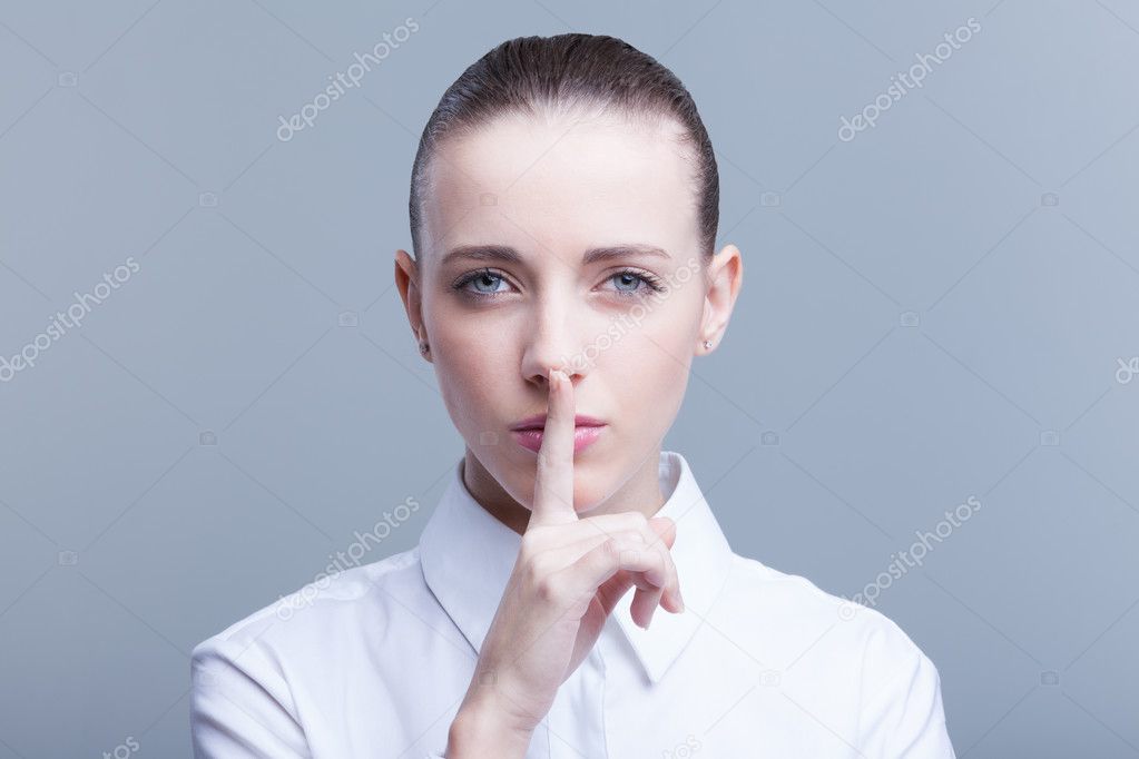 beautiful woman with finger on her lips telling you to hush