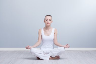 Genç bayan yoga yapıyor.