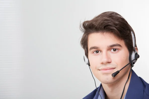 Porträtt av en leende call center anställd bära headsetet — Stockfoto