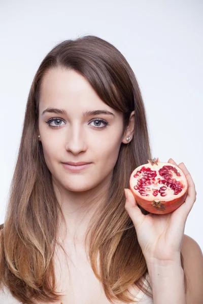 Healthy lifestyle. Beautiful brunette holding pomegranate — Stock Photo, Image