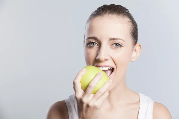 Mädchen essen grünen Apfel Stockbild