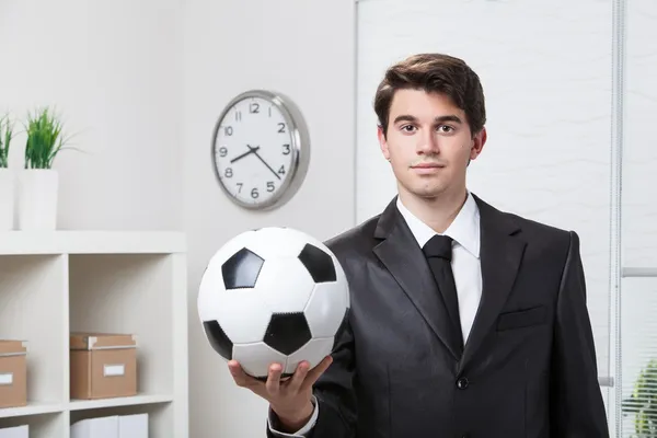 Affärsman som håller en fotboll — Stockfoto