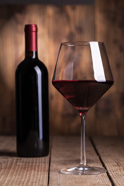 Glass of wine with bottles — Stock Photo, Image