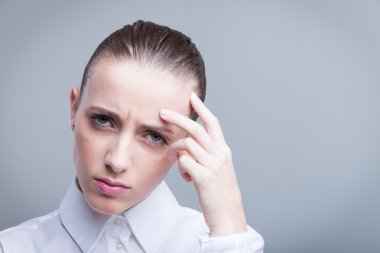 Alnını acı içinde tutan bir kadın.