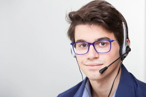 Unga leende affärsman med headset — Stockfoto