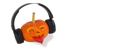 Beyaz arka planda müzik için kulaklık takan Cadılar Bayramı balkabağı. Bibersiz dil. Balkabağından Jack Lantern