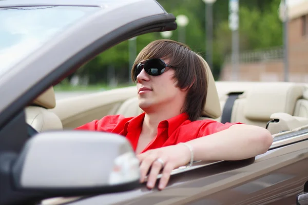 Joven hombre de negocios sentado en un coche . — Foto de Stock