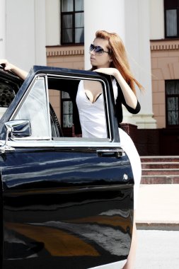 Retro bir araba ile büyüleyici bir genç kadın