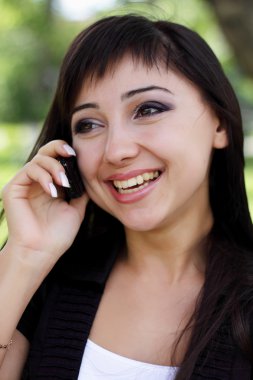 Kadın telefonda konuşurken bahar Parkı.