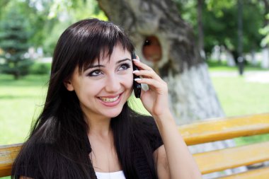 Kadın telefonda konuşurken bahar Parkı.