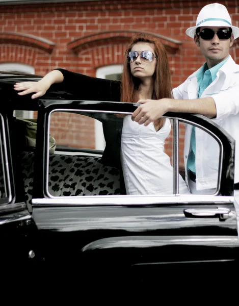 Una pareja joven con un coche retro — Foto de Stock