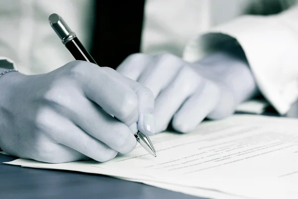 Persons hånd underskrive et vigtigt dokument - Stock-foto