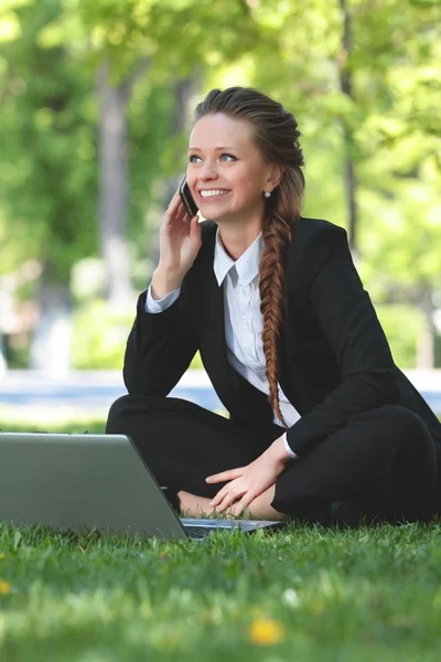 Ung kvinna på våren park prata i telefon. — Stockfoto