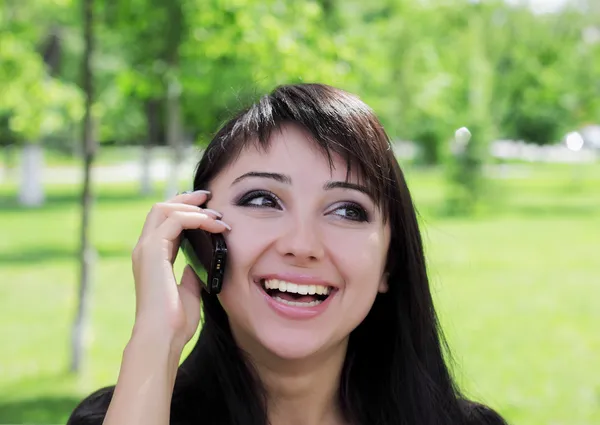 Young woman at spring park talking on the phone. — Stock Photo, Image