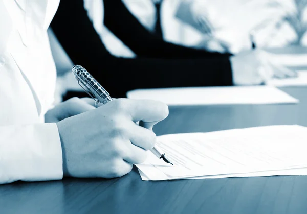 Person's hand signing an important document — Stock Photo, Image