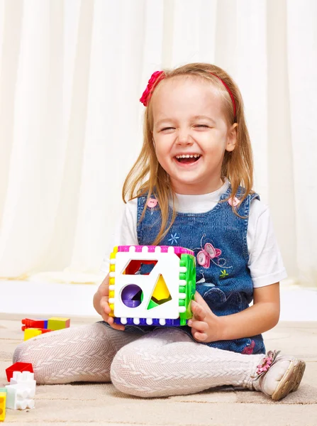 Маленькая девочка играет с красочными игрушками — стоковое фото