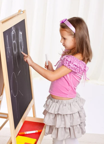 一个小女孩在粉笔写上石墨板. — Φωτογραφία Αρχείου