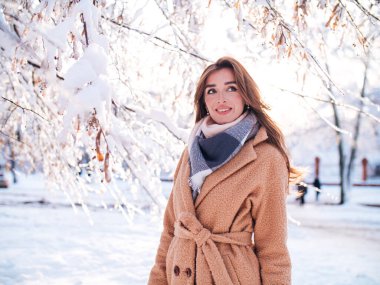 Kar içindeki kız paltolu.