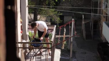 man hanging things on the balcony