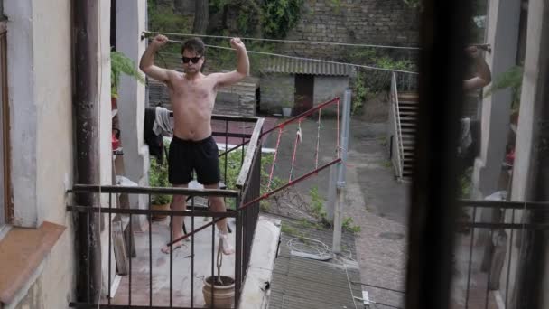 Чоловік засмагає на балконі — стокове відео
