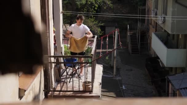 Man hanging things on the balcony — Stock Video