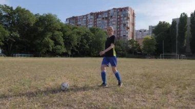 Kız futbolcu futbol oynamadan önce sallanan bacakları ısıtıyor.
