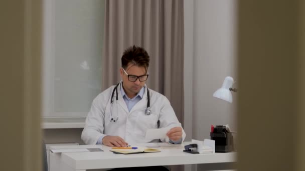 Gözlüklü Bir Erkek Doktor Röntgene Bakar Verileri Karşılaştırır Kapıdaki Boşluktan — Stok video