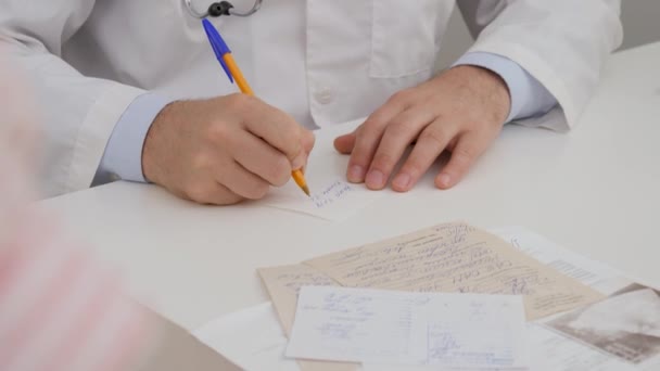 Male Doctor Writes Piece Paper Directions Tests Passes Patient — ストック動画