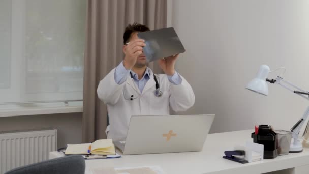 Male Doctor Glasses Gown Looks Ray Patient Writes Data Computer — Video