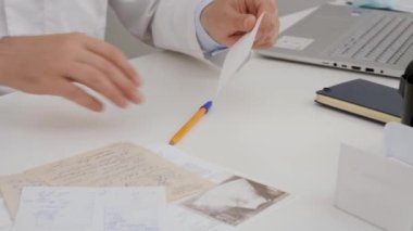 doctors take their hands on a piece of paper on the table on which they write what medicine should be taken for treatment