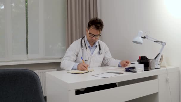 Доктор Записывает Данные Блокнот Смотрит Рентген — стоковое видео