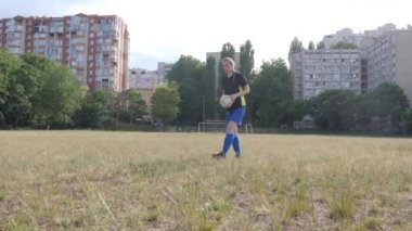 Kız futbolcu topu Cristiano Ronaldo tarzında serbest vuruş için atıyor.